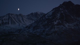 AK0001_1119 - 4K stock footage aerial video the moon over the snow covered Chugach Mountains at night, Alaska
