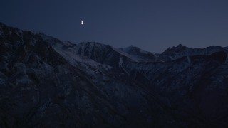 AK0001_1120 - 4K aerial stock footage the moon over the snow covered Chugach Mountains at night, Alaska