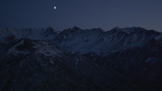 AK0001_1121 - 4K stock footage aerial video the moon over the snow covered Chugach Mountains at night, Alaska