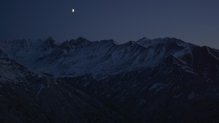 AK0001_1122 - 4K aerial stock footage the moon over the snow covered Chugach Mountains at night, Alaska