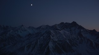 AK0001_1133 - 4K stock footage aerial video the moon over the snow covered Chugach Mountains at night, Alaska