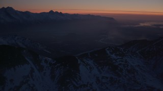 AK0001_1136 - 4K aerial stock footage approach river valley, snow covered Chugach Mountains, Alaska, twilight