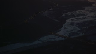 AK0001_1141 - 4K aerial stock footage heavy traffic crossing Glenn Highway bridge at night, in snow, Alaska