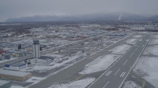AK0001_1147 - 4K aerial stock footage lift off from snowy Merrill Field, head across East 5th Ave, Anchorage, Alaska
