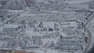 AK0001_1153 - 4K aerial stock footage approaching snow covered neighborhoods in Fort Richardson, Anchorage, Alaska