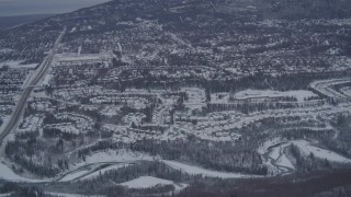 AK0001_1160 - 4K aerial stock footage approaching snow covered neighborhoods in Eagle River Valley, Alaska