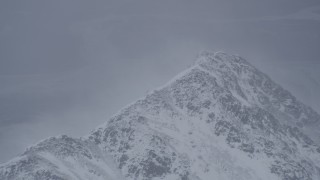 AK0001_1209 - 4K aerial stock footage wind blowing snow off mountain peak, Chugach Mountains, Alaska