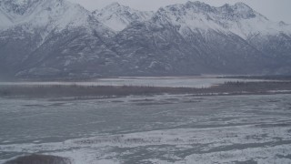 AK0001_1218 - 4K aerial stock footage flying toward lake, snow capped mountains in the Knik River Valley, Alaska