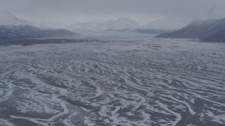 AK0001_1228 - 4K aerial stock footage flying over snowy Knik River Valley to Knik Glacier, Chugach Mountains, Alaska