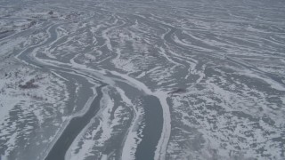 AK0001_1233 - 4K aerial stock footage flying over rivers in snowy Knik River Valley, Alaska