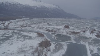 AK0001_1234 - 4K aerial stock footage flying over rivers in the snowy Knik River Valley, Alaska