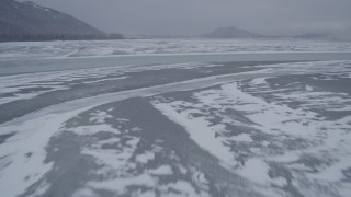 AK0001_1260 - 4K aerial stock footage flying over a river and frozen ground, Knik River Valley, Alaska