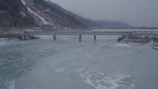 AK0001_1277 - 4K stock footage aerial video flying over frozen ground toward Old Glenn Highway bridge, Butte, Alaska in snow
