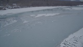 AK0001_1280 - 4K stock footage aerial video flying over snow covered trees revealing icy river, Butte, Alaska