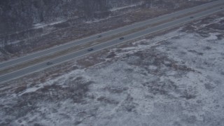AK0001_1304 - 4K aerial stock footage video following Glenn Highway through snow covered ground, Anchorage, Alaska