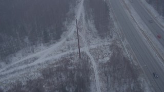 AK0001_1308 - 4K aerial stock footage following Glenn Highway and forest through snow, Anchorage, Alaska