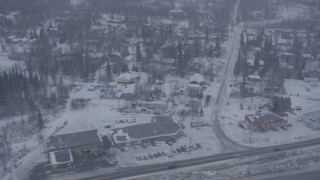 AK0001_1311 - 4K aerial stock footage flying by neighborhoods, reveal Glenn Highway, falling snow, Eagle River, Alaska