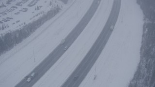 AK0001_1318 - 4K aerial stock footage light traffic on Glenn Highway in falling snow, Anchorage, Alaska