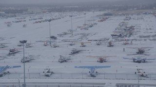 AK0001_1326 - 4K aerial stock footage airplanes parked on snowy runway at Merrill Field, Anchorage, Alaska