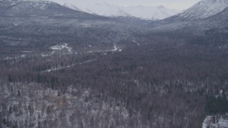 AK0001_1333 - 4K aerial stock footage flying over snow covered country roads through woods, Anchorage, Alaska