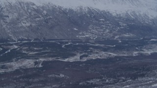 AK0001_1345 - 4K stock footage aerial video flying over snowy slope revealing a rocky range in the Chugach Mountains, Alaska