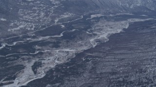 AK0001_1347 - 4K aerial stock footage tilting up along Eagle River revealing snow covered Chugach Mountains, Alaska