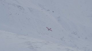 AK0001_1349 - 4K aerial stock footage tilting with airplane flying over snow covered slope, Chugach Mountains, Alaska