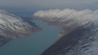 AK0001_1368 - 4K aerial stock footage Eklutna Lake surrounded by snow capped Chugach Mountains, Alaska