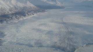 AK0001_1381 - 4K aerial stock footage a lake between base of mountain and the Knik Glacier in snow, Alaska