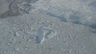 AK0001_1382 - 4K aerial stock footage an icy lake at edge of snow covered Knik Glacier, Alaska
