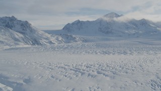 AK0001_1399 - 4K aerial stock footage the snow covered Knik Glacier spilling down the Chugach Mountains, Alaska