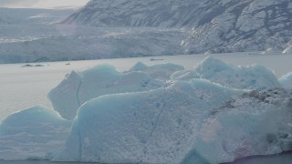 AK0001_1433 - 4K aerial stock footage orbiting a chunk of glacial ice in Inner Lake George, Alaska in snow