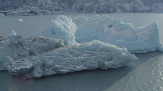 AK0001_1437 - 4K aerial stock footage flying over a chunk of glacial ice on Inner Lake George, Alaska in snow