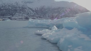 AK0001_1439 - 4K aerial stock footage flying by a piece of glacial ice on Inner Lake George, Alaska in snow