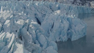AK0001_1447 - 4K aerial stock footage flying along edge of a snow covered glacier on Inner Lake George, Alaska