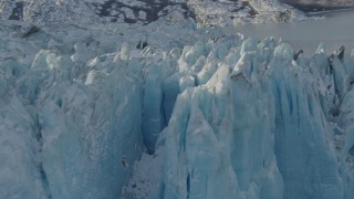 AK0001_1448 - 4K aerial stock footage flying along edge of a snow covered glacier on Inner Lake George, Alaska