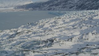 AK0001_1451 - 4K aerial stock footage flying over surface of snow covered glacier on Inner Lake George, Alaska