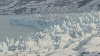 AK0001_1452 - 4K aerial stock footage flying toward edge of the snow covered glacier on Inner Lake George, Alaska