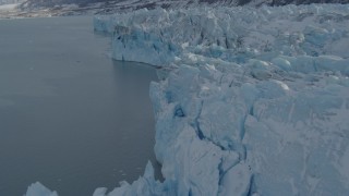AK0001_1454 - 4K aerial stock footage flying over edge of snow covered glacier on Inner Lake George, Alaska