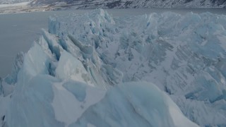 AK0001_1455 - 4K aerial stock footage flying over snowy, jagged surface, edge of glacier on Inner Lake George, Alaska
