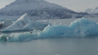 AK0001_1463 - 4K aerial stock footage orbiting ice on Inner Lake George, reveal snowy glacier and Chugach Mountains, Alaska