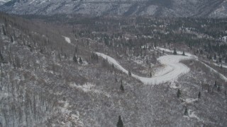 AK0001_1512 - 4K aerial stock footage road through snowy, wooded foothills, Chugach Mountains, Alaska