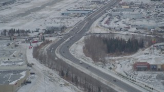 AK0001_1518 - 4K aerial stock footage Glenn Highway, 5th Avenue, snowy Merrill Field, Downtown Anchorage, Alaska