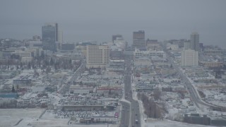 AK0001_1519 - 4K aerial stock footage snow covered Downtown Anchorage skyline seen from East 5th Avenue, Alaska