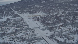 AK0001_1535 - 4K aerial stock footage following Eagle River Loop Road through snow covered forest, Alaska
