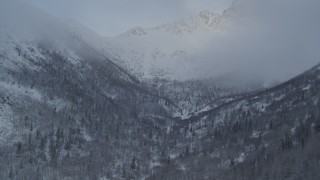 AK0001_1556 - 4K aerial stock footage a narrow wooded valley, snowy mountains, Chugach Mountains, Alaska