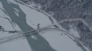 AK0001_1572 - 4K aerial stock footage a reverse view of the Old Glenn Highway bridges spanning Knik River, Alaska in snow