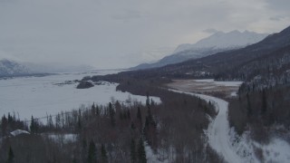 AK0001_1579 - 4K aerial stock footage flying over Knik River Road in snow covered Knik River Valley, Alaska