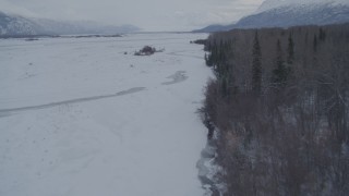 AK0001_1585 - 4K aerial stock footage flying over rivers in the snow covered Knik River Valley, Alaska