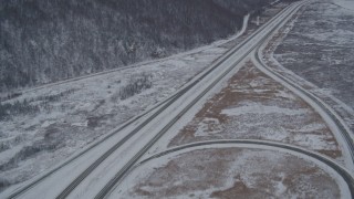 AK0001_1613 - 4K aerial stock footage tilting up the length of snow covered Glenn Highway, Anchorage, Alaska